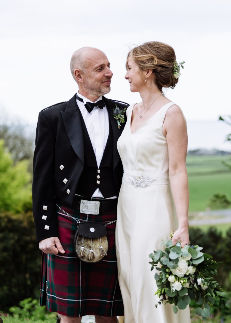 Cream silk wedding dress with mesh belt and green jacket