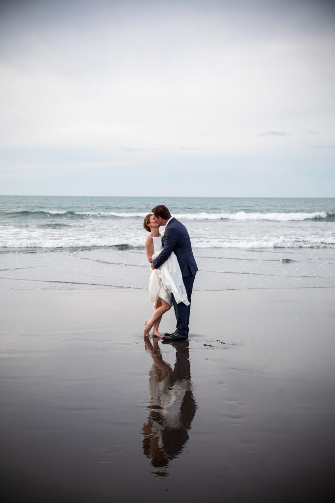 bride and groom on new zealand beach