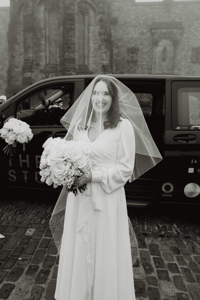 a black and white photograph of the bride in her wedding dress