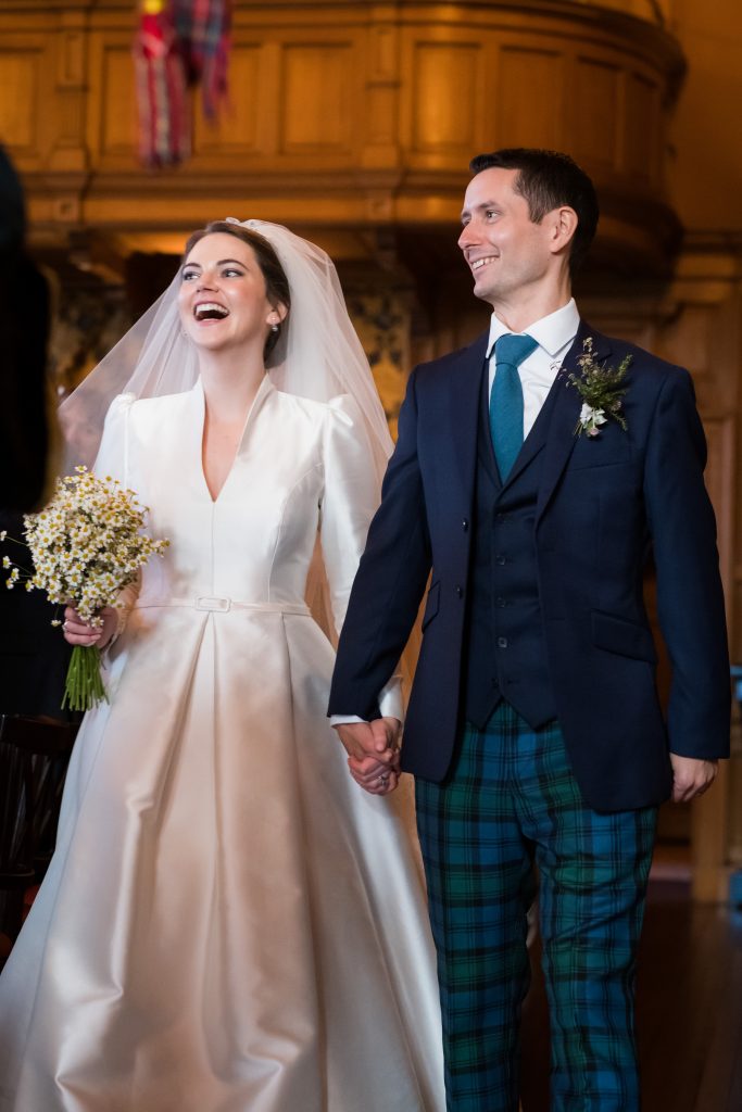 the bride in her timeless wedding dress with the V-neck detail and pleated skirt