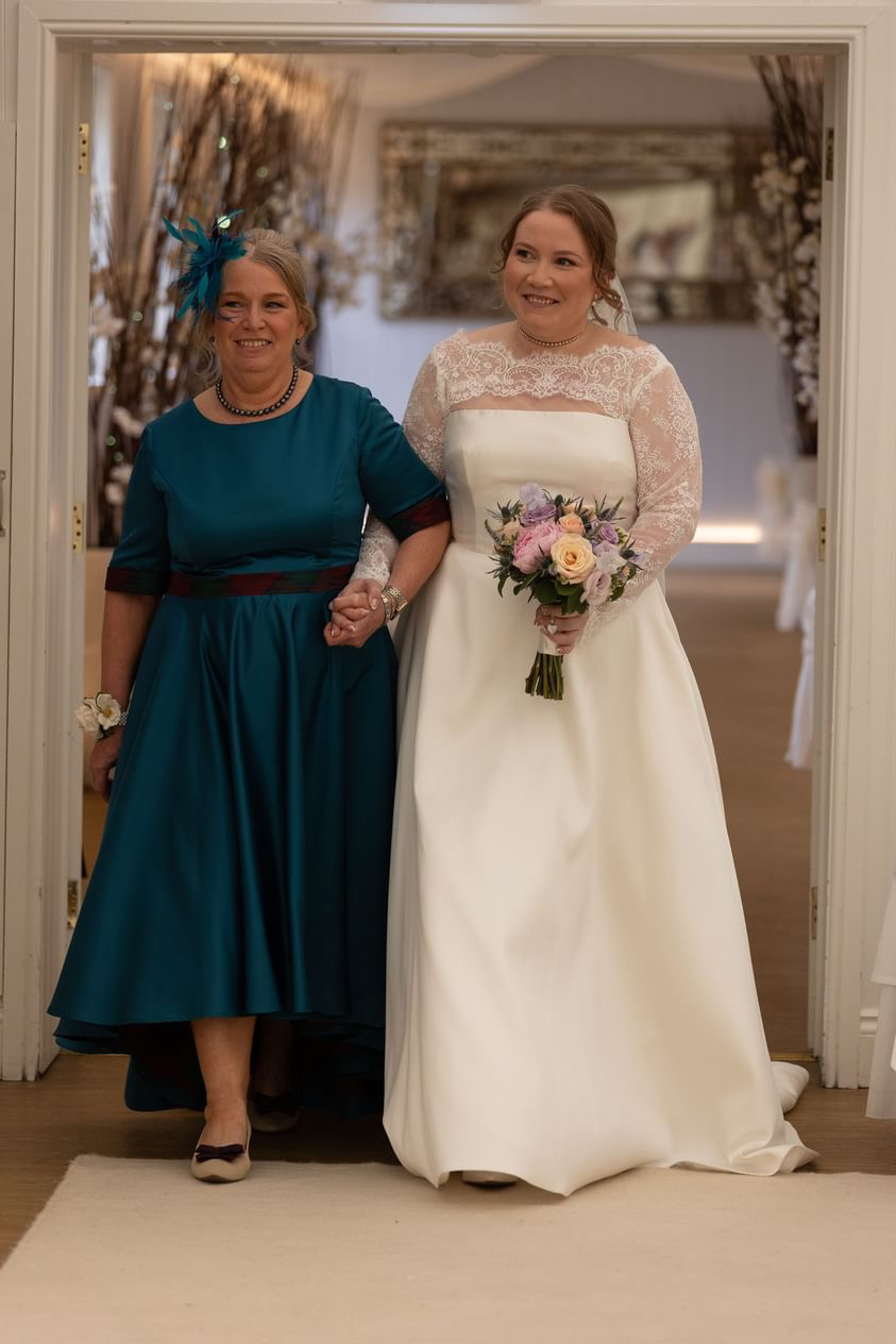 Mother of the bride in teal dress with tartan silk