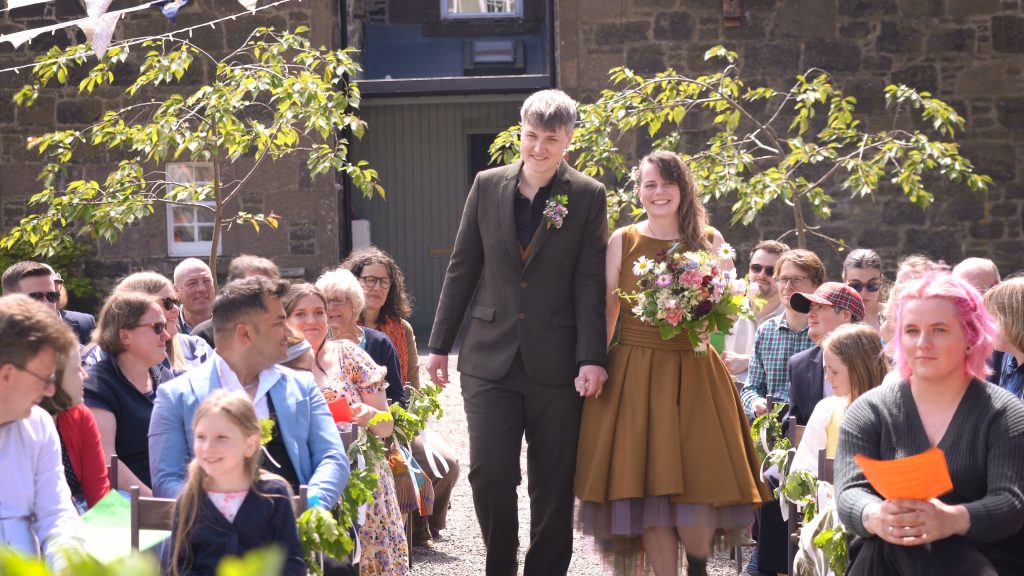 Same sex wedding in mustard coloured wool dress. 