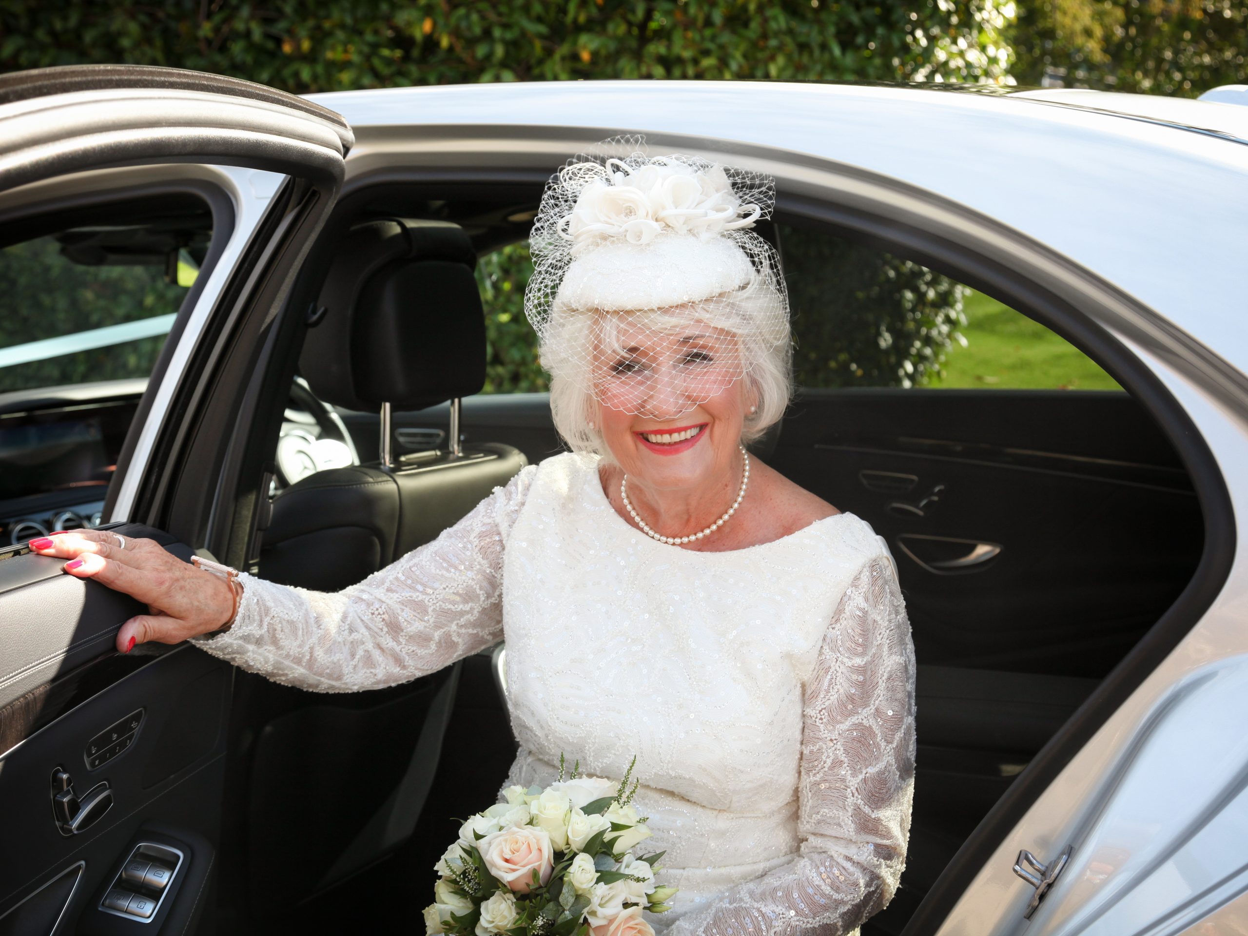 mature bride in lace wedding dress and pillar box hat