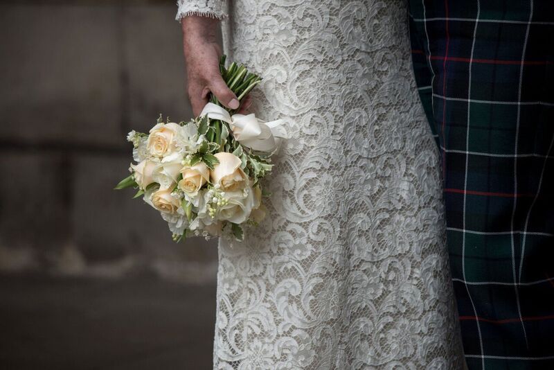 close up of lace wedding dress for mature bride and lovely flowers