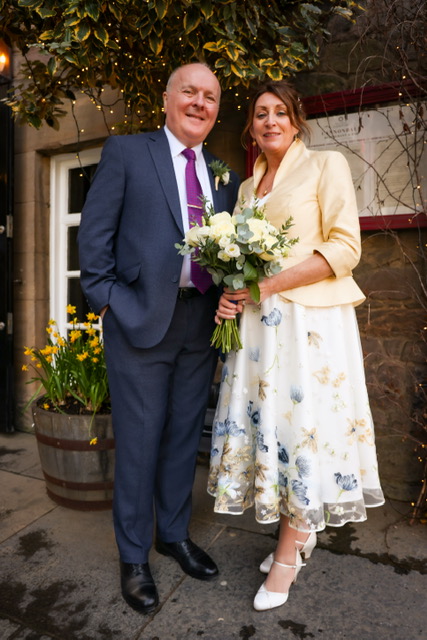 grown up bride in embroidered wedding dress and buttermilk coloured silk jacket with peplum